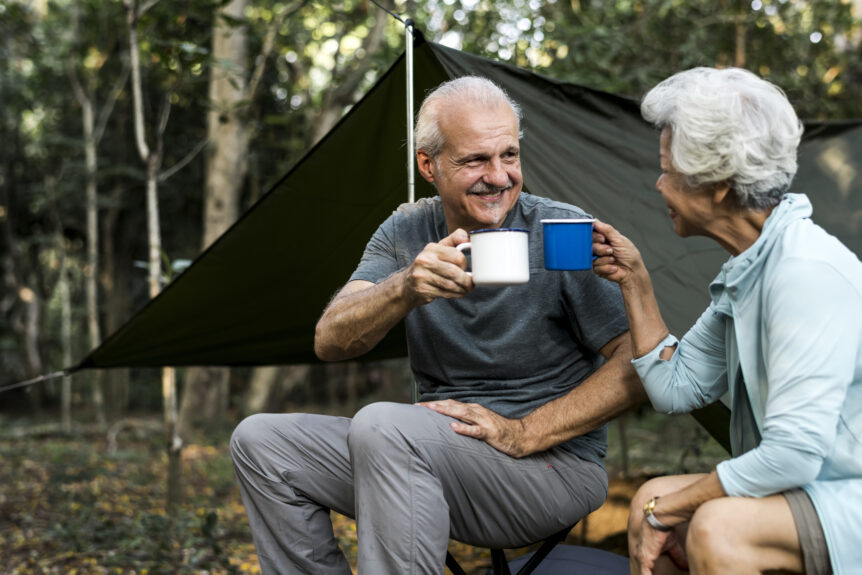 A retired couple enjoying coffee while on vacation, representing the stability and peace of mind that guaranteed lifetime income provides during retirement