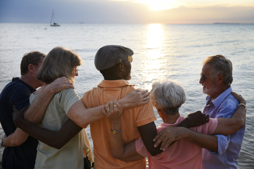 A retired couple enjoying a sunset walk by the beach, symbolizing financial security through retirement income strategies.