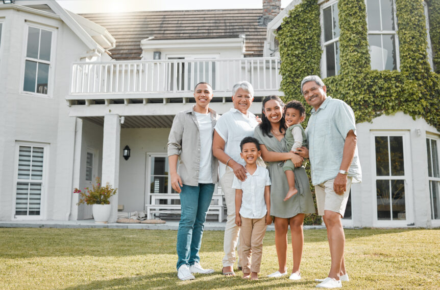 Family standing confidently in front of their home with a serene sunset, symbolizing financial freedom through SureWealth strategies