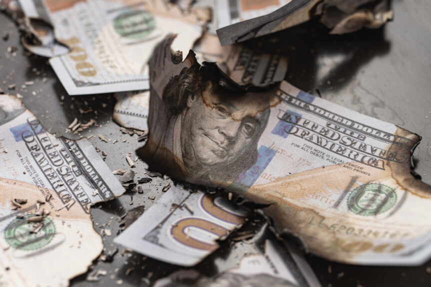 A stack of burnt cash, representing the challenges of traditional retirement planning.